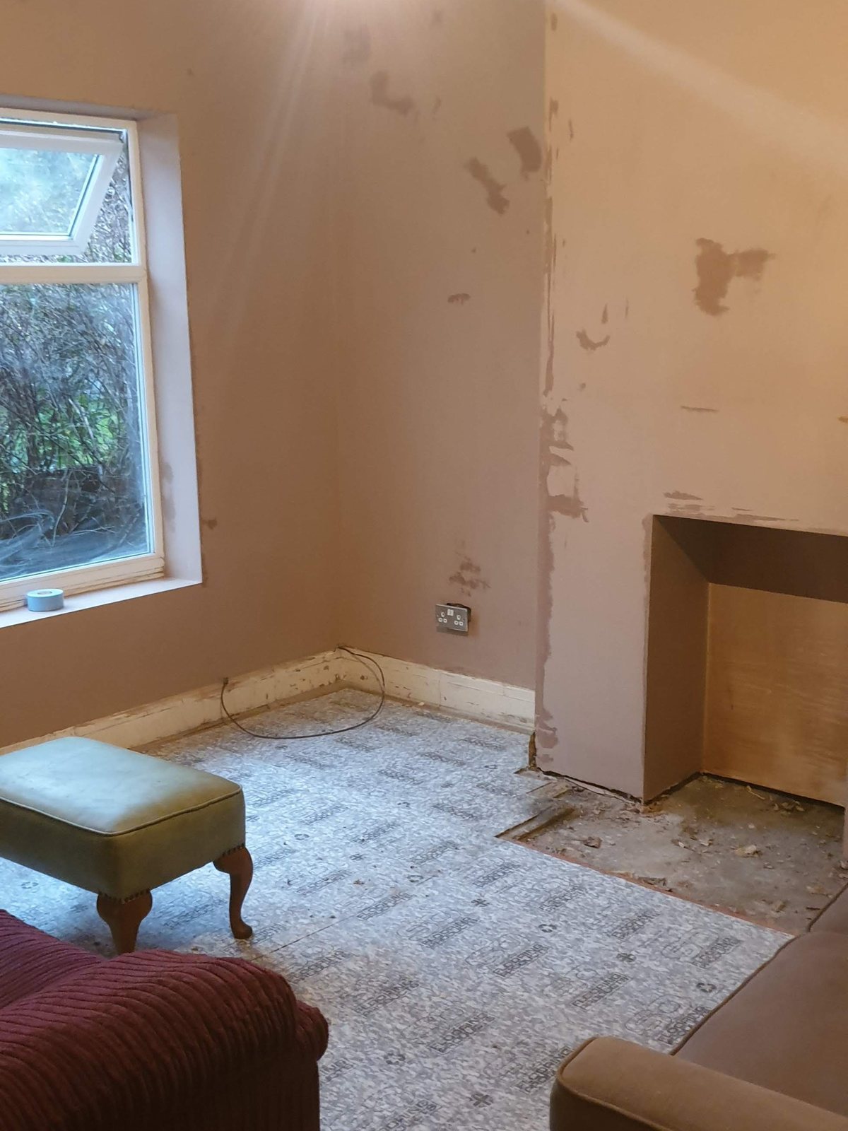 A living room skimmed from wall to wall with the furniture still in place