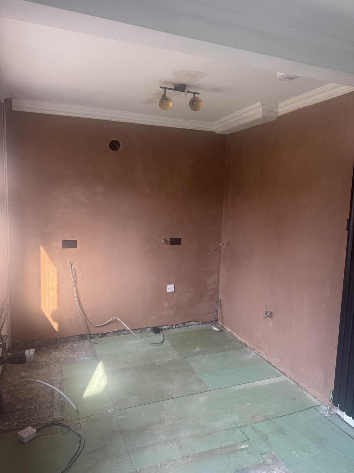 A room plastered up to the original coving, the plaster drying in the sunlight